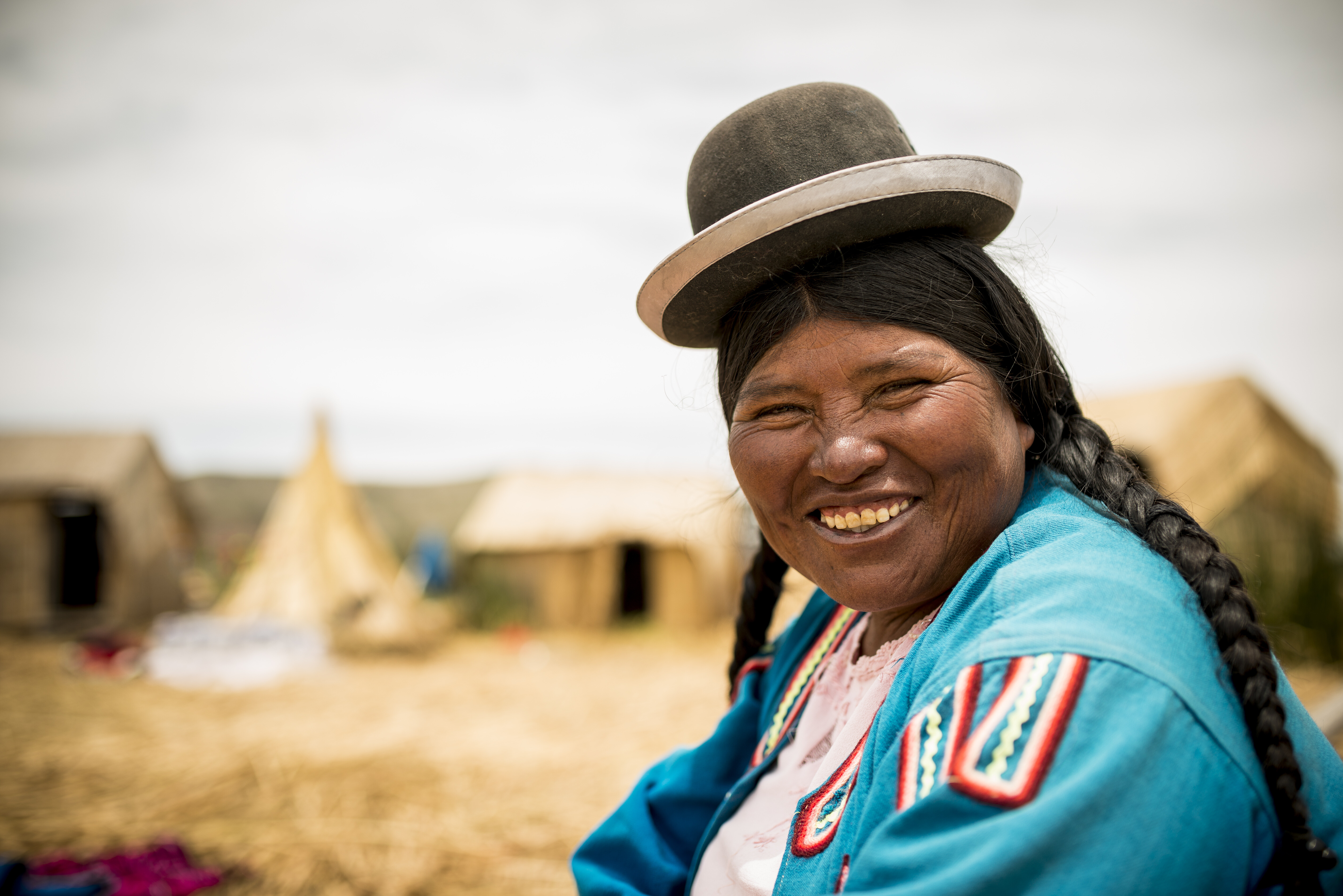 Smiling woman in traditional attire enjoying a sunny day outdoors